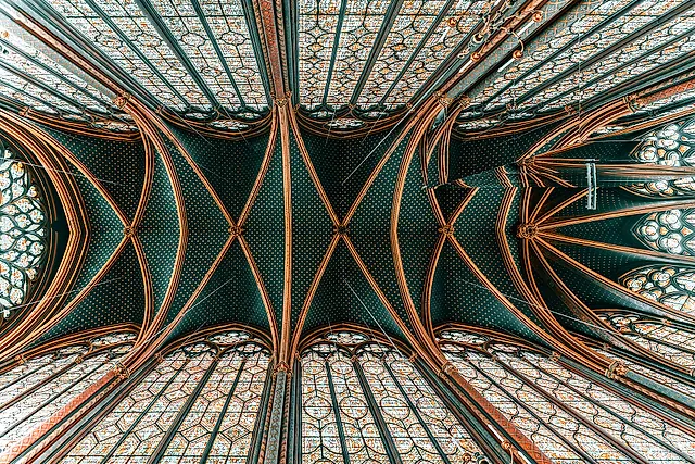 The vault of the Sainte-Chapelle seen from below, in green and gold, with the stained-glass windows rising on both sides.